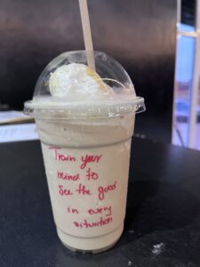 This photo shows a frozen coffee with a quote written on the take away cup.